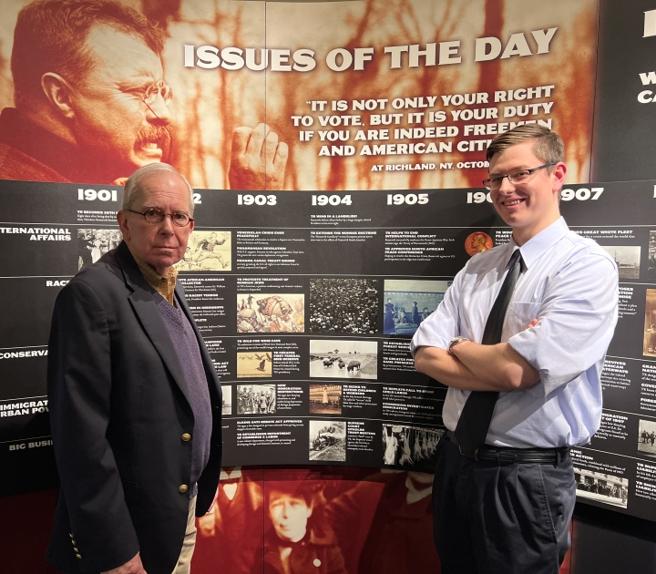 Stanton Hudson and Jacob Riedel in front of a historical sign