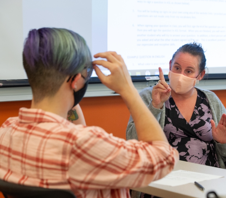 professor teaching a student American Sign Language