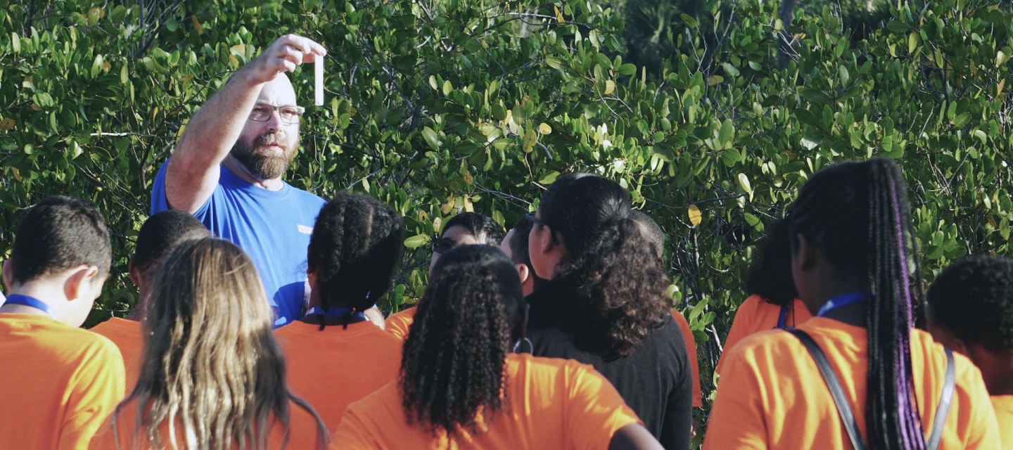 Teacher shows test tube to students 